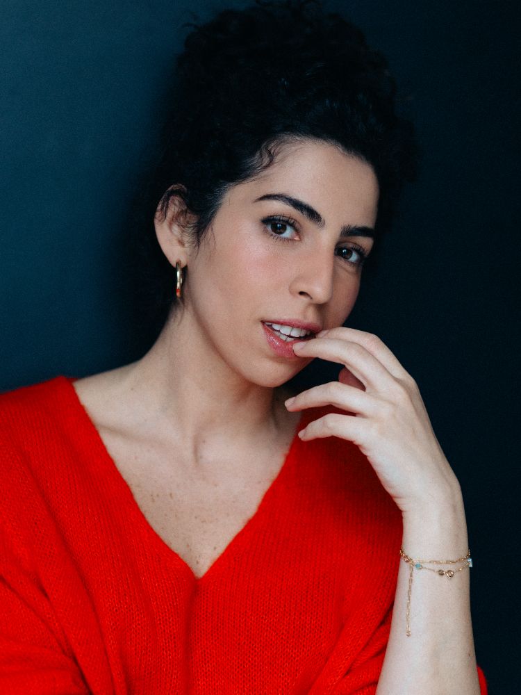 Retrato de atriz de blusa vermelha em fundo escuro